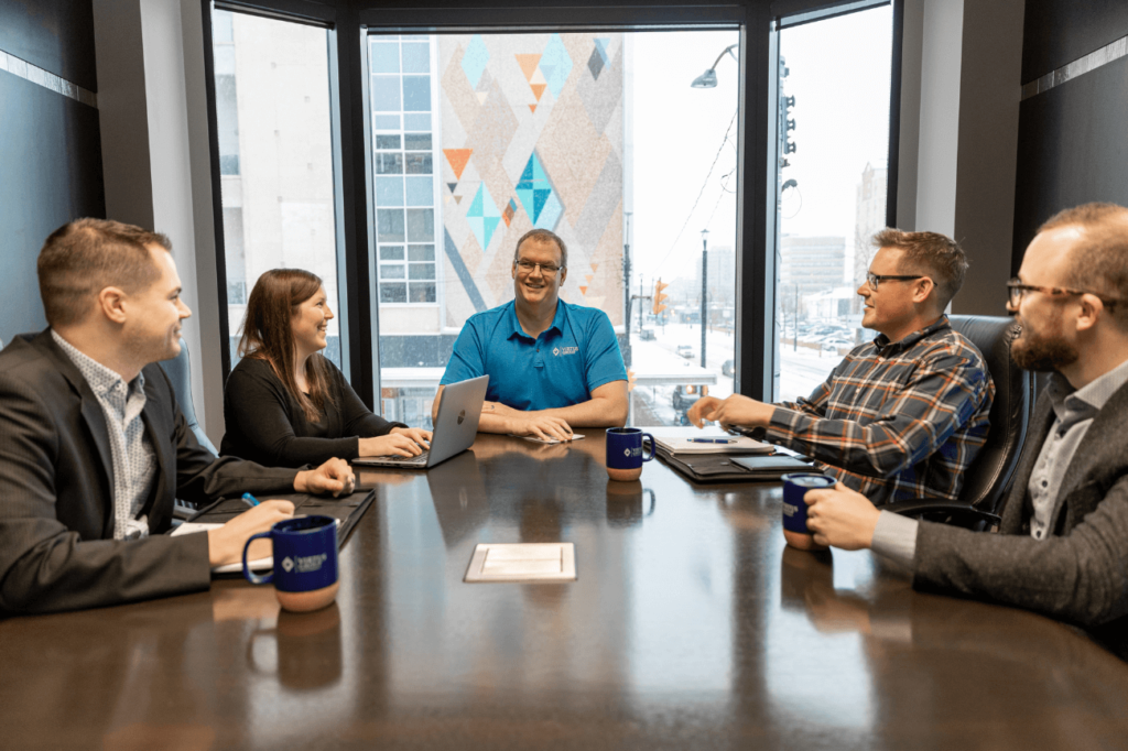 Business advisors at Virtus Group gathered around conference room table - Virtus Group LLP